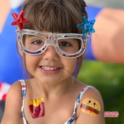 Smiling girl wearing Boo-Boo Buddies® french fries and burger bandages on shoulders – fun kids bandages for summer, pool parties, or playtime