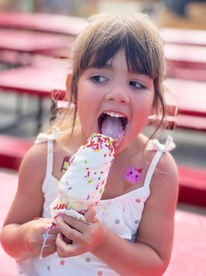 Girl eating ice cream cone with rainbow sprinkles, wearing Boo-Boo Buddies® pink ice cream cone bandage on shoulder – fun kids bandage for summer