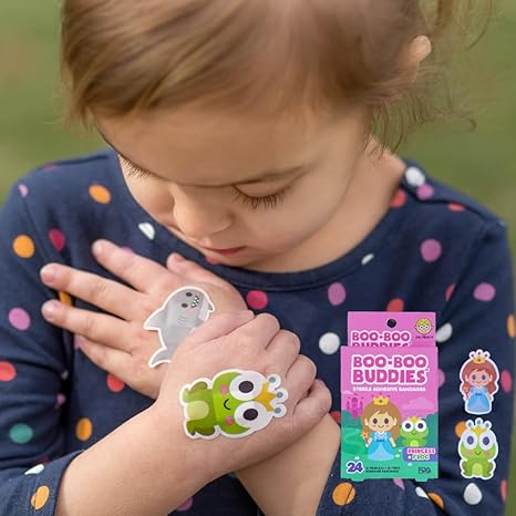 Toddler with frog and whale character bandages from Boo-Boo Buddies® – fun adhesive bandages for kids featuring princess and sea animal themes
